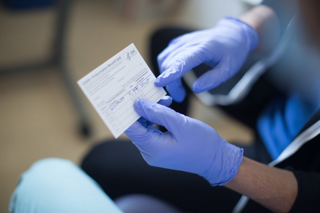 Person holding COVID vaccination card
