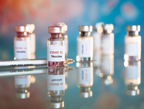 Eight small vials labeled COVID-19 vaccine