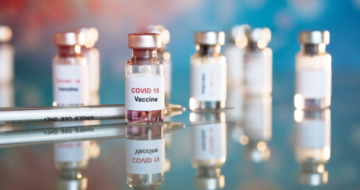 Eight small vials labeled COVID-19 vaccine
