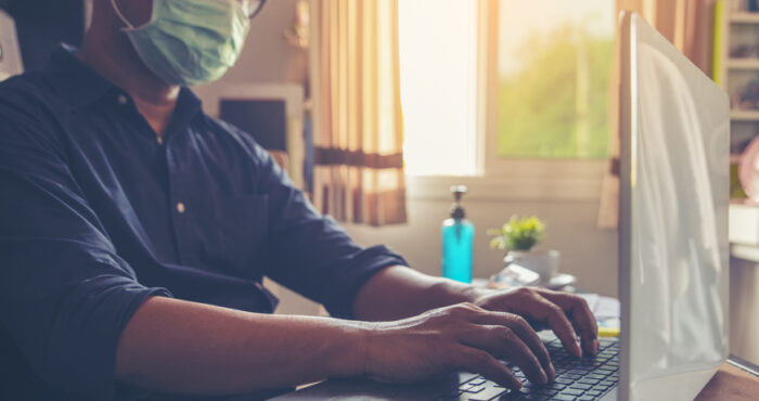 person wearing mask on computer