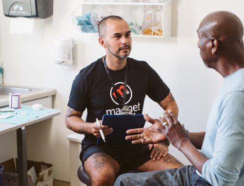 A sexual health clinician talking to a patient in a clinical room.