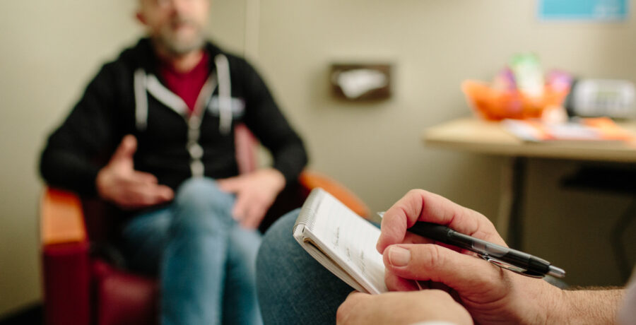 A counselor sitting with a client in a counseling room at SFAF.