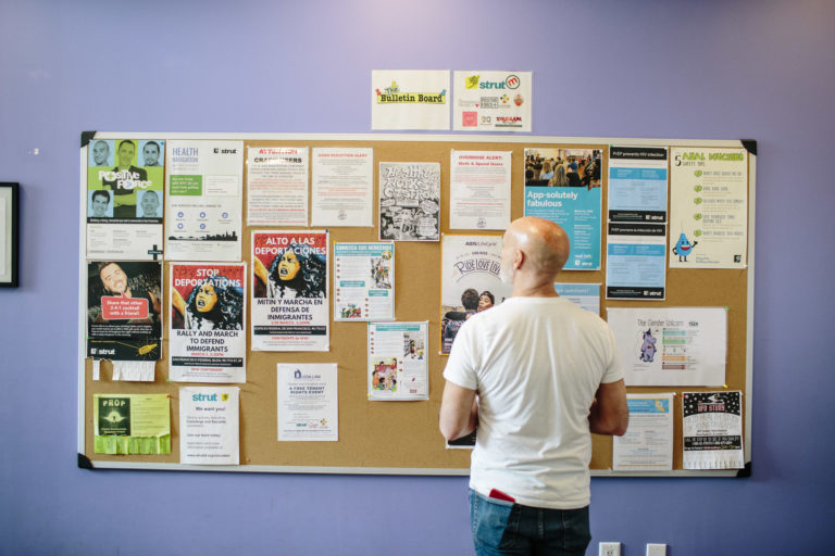 person looking at bulletin board of events at Strut