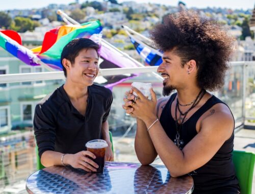 Two people sitting drinking coffee on patio at SFAF health center Strut