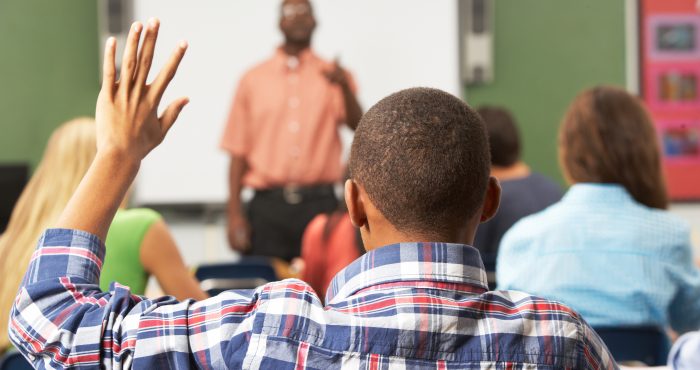 person raising hand classroom