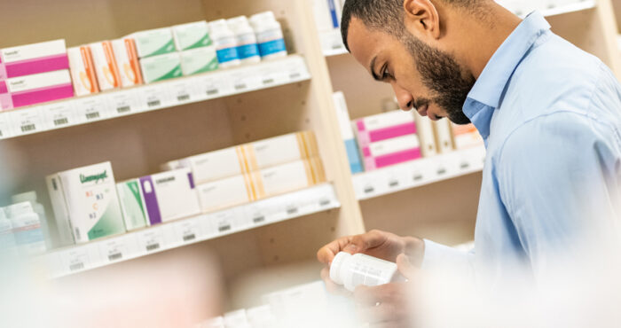 Pharmacist looking at medication bottle