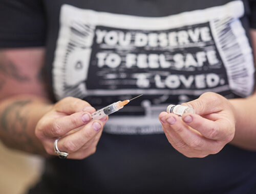 Person holding syringe with Narcan