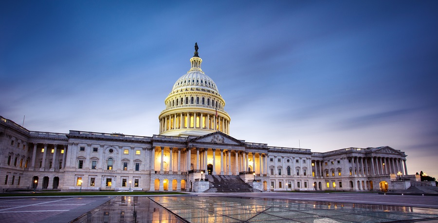 Capitol building in Washington DC illuminated against a stormy sky