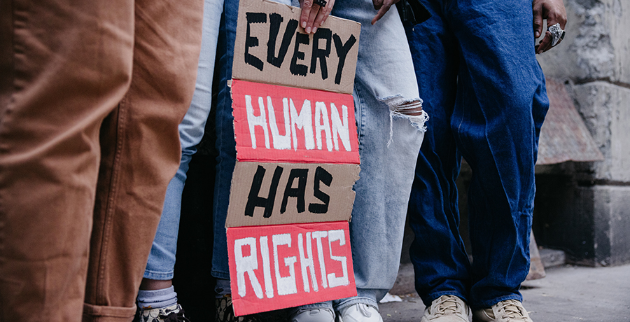 Group of people holding a sign "Every Human Has Rights"