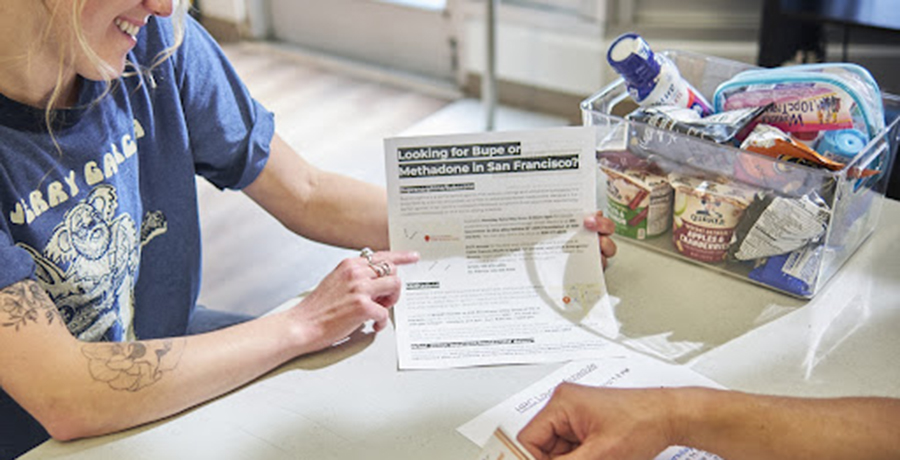 MAT coordinator holds a flier explaining drug treatment options.