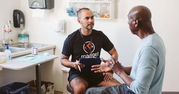 A sexual health clinician talking to a patient in a clinical room.