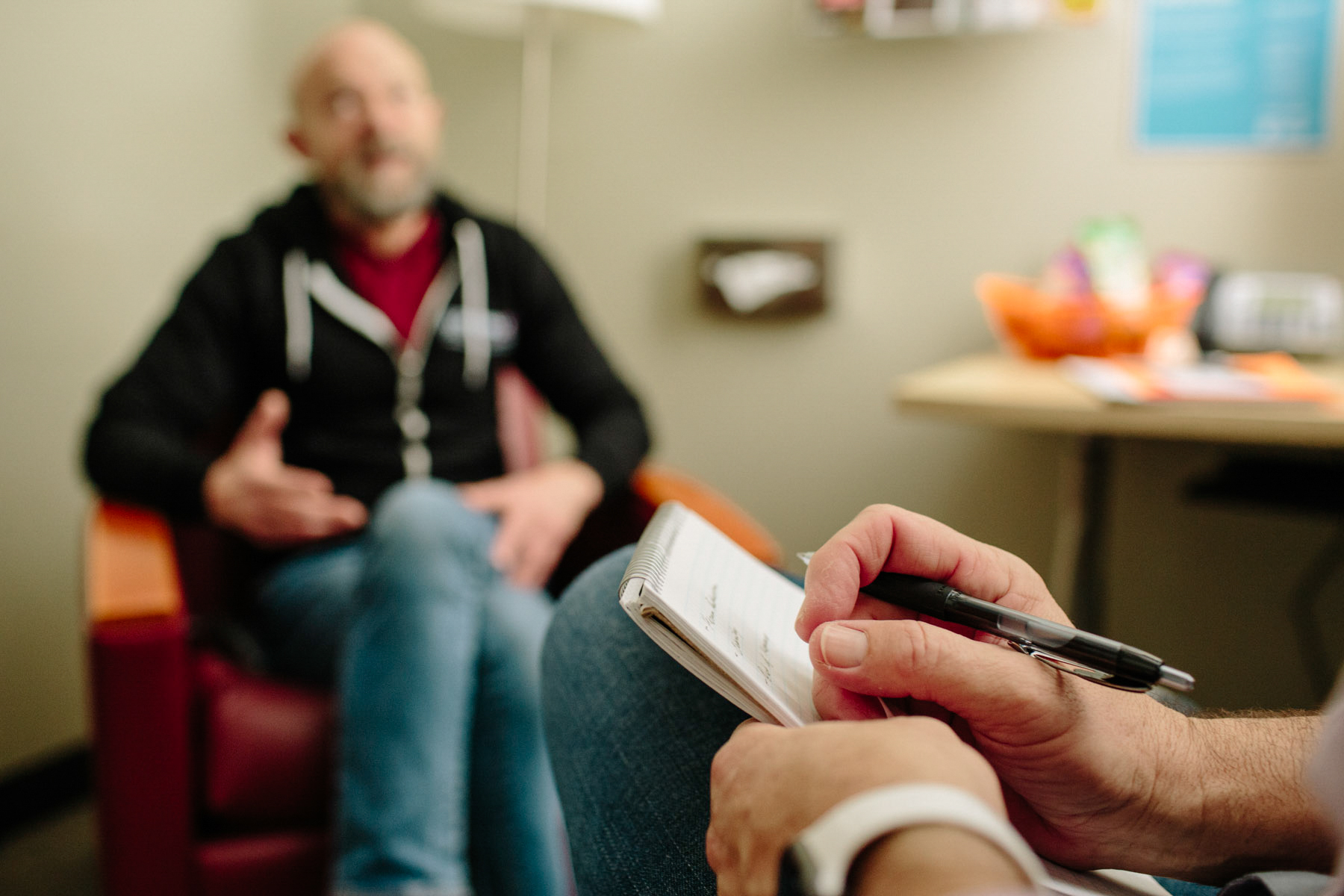 A counselor sitting with a client in a counseling room at SFAF.