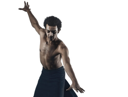 Portrait of African American male ballet dancer on white and black studio background. Classical ballet concept. Classic choreography concepts