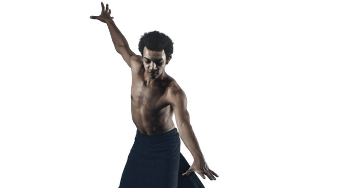 Portrait of African American male ballet dancer on white and black studio background. Classical ballet concept. Classic choreography concepts