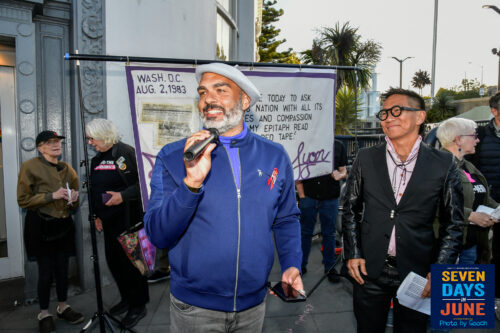 Dr. Tyler TerMeer holds a microphone and speaks at a community rally in San Francisco.