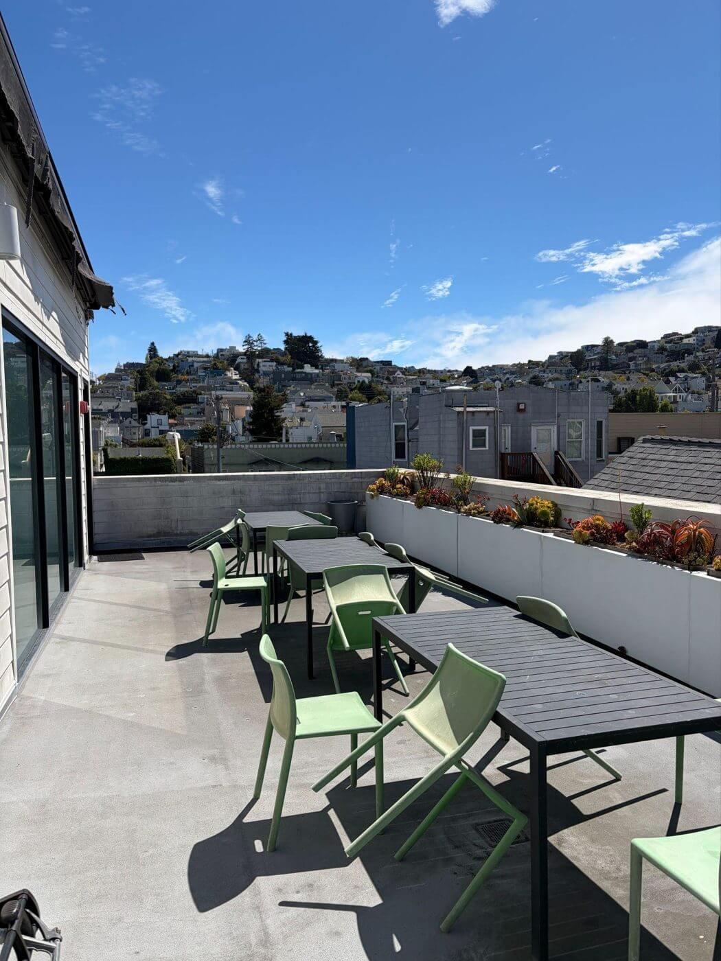 Tables and chairs on the 3rd floor rear patio at Strut.